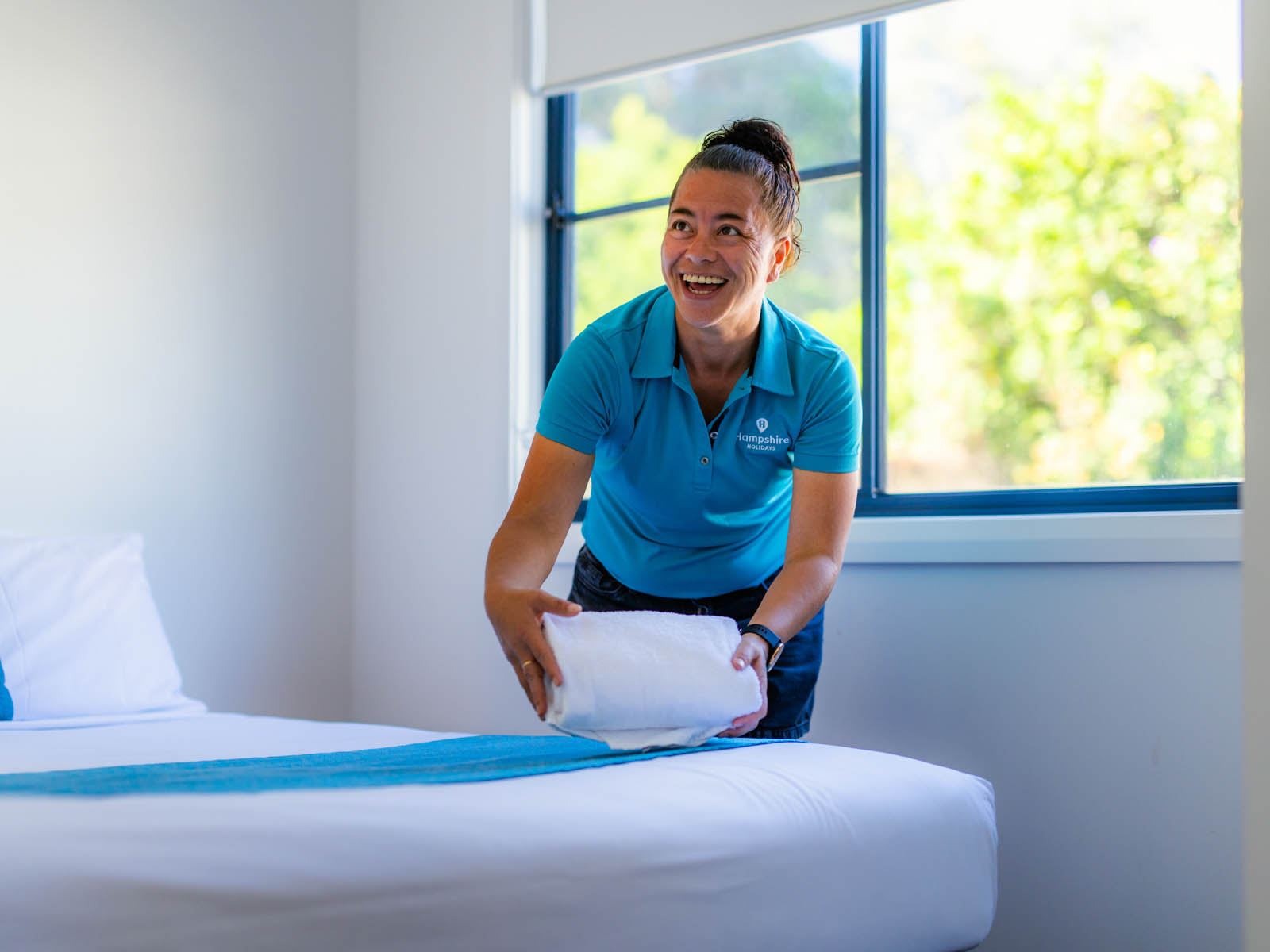 A housekeeper making a bed